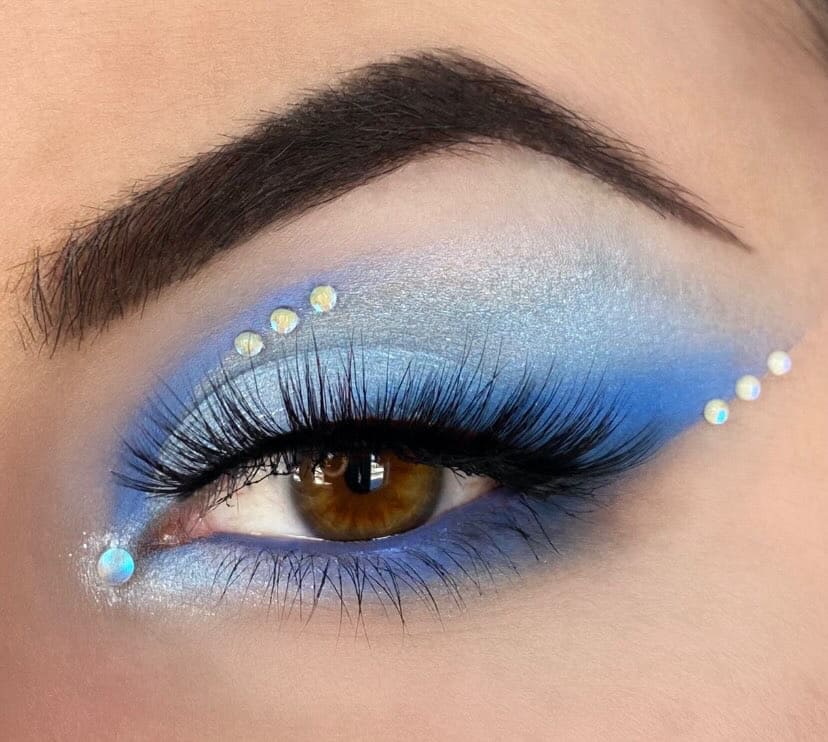 Woman with light skin wearing eyeshadow in blue metallic and matte shades.