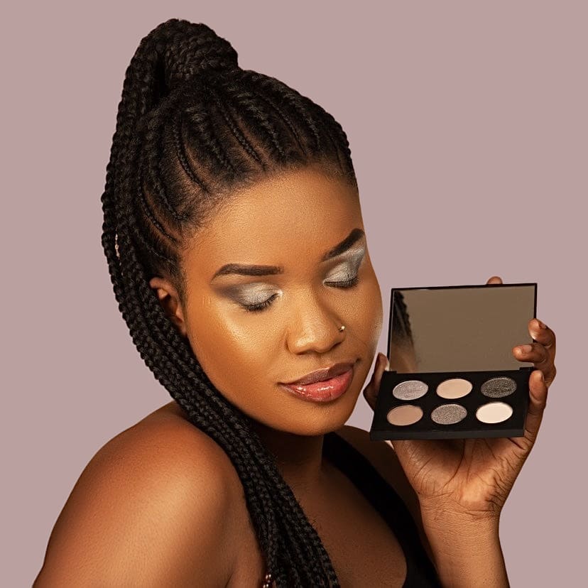 Woman with dark skin wearing eyeshadow in cool brown silvery metallic and matte shades.