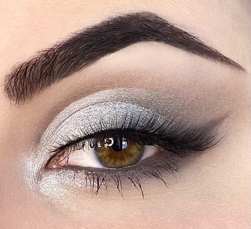 Woman with light skin wearing eyeshadow in cool brown silvery metallic and matte shades.